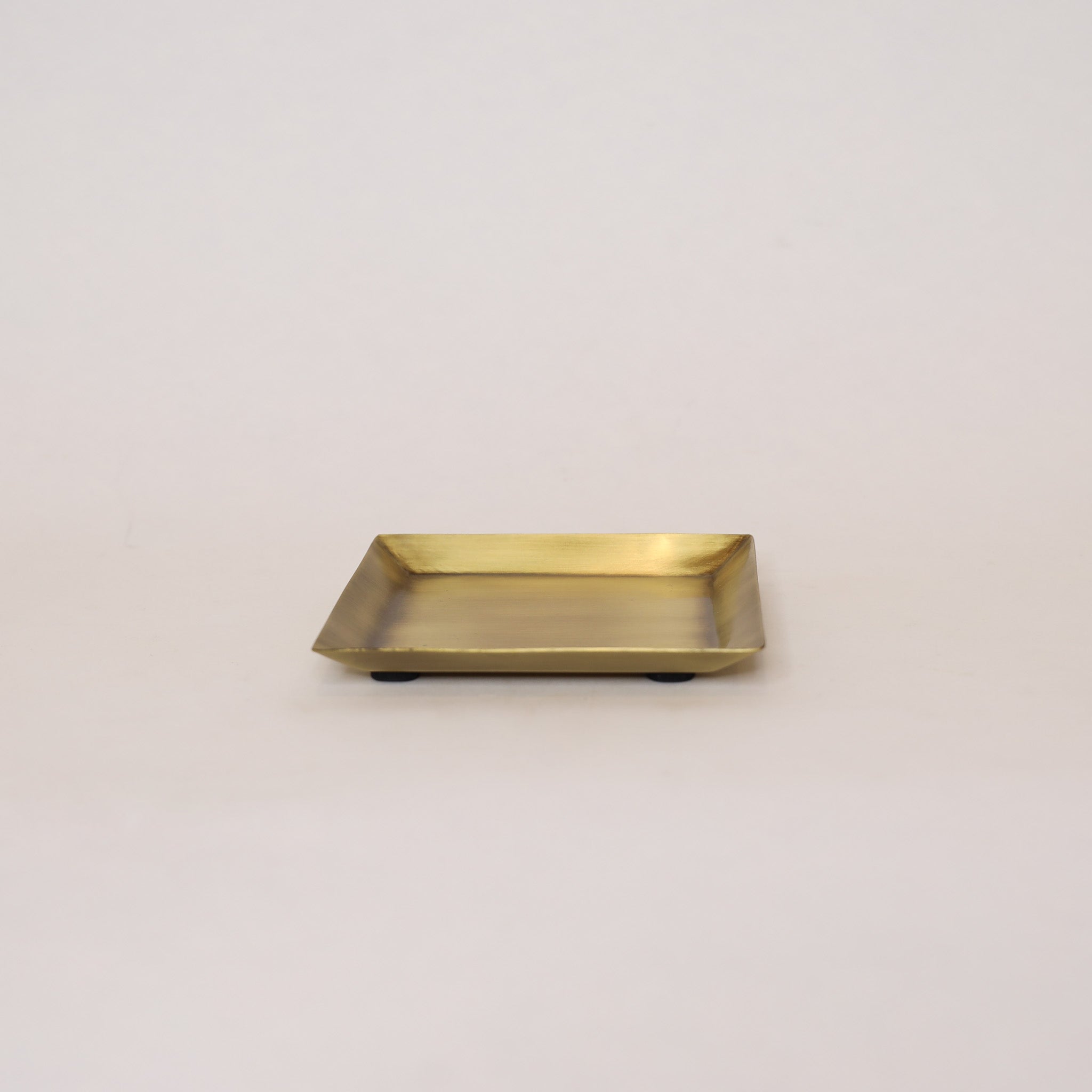 Gold rectangular tray on a light beige background