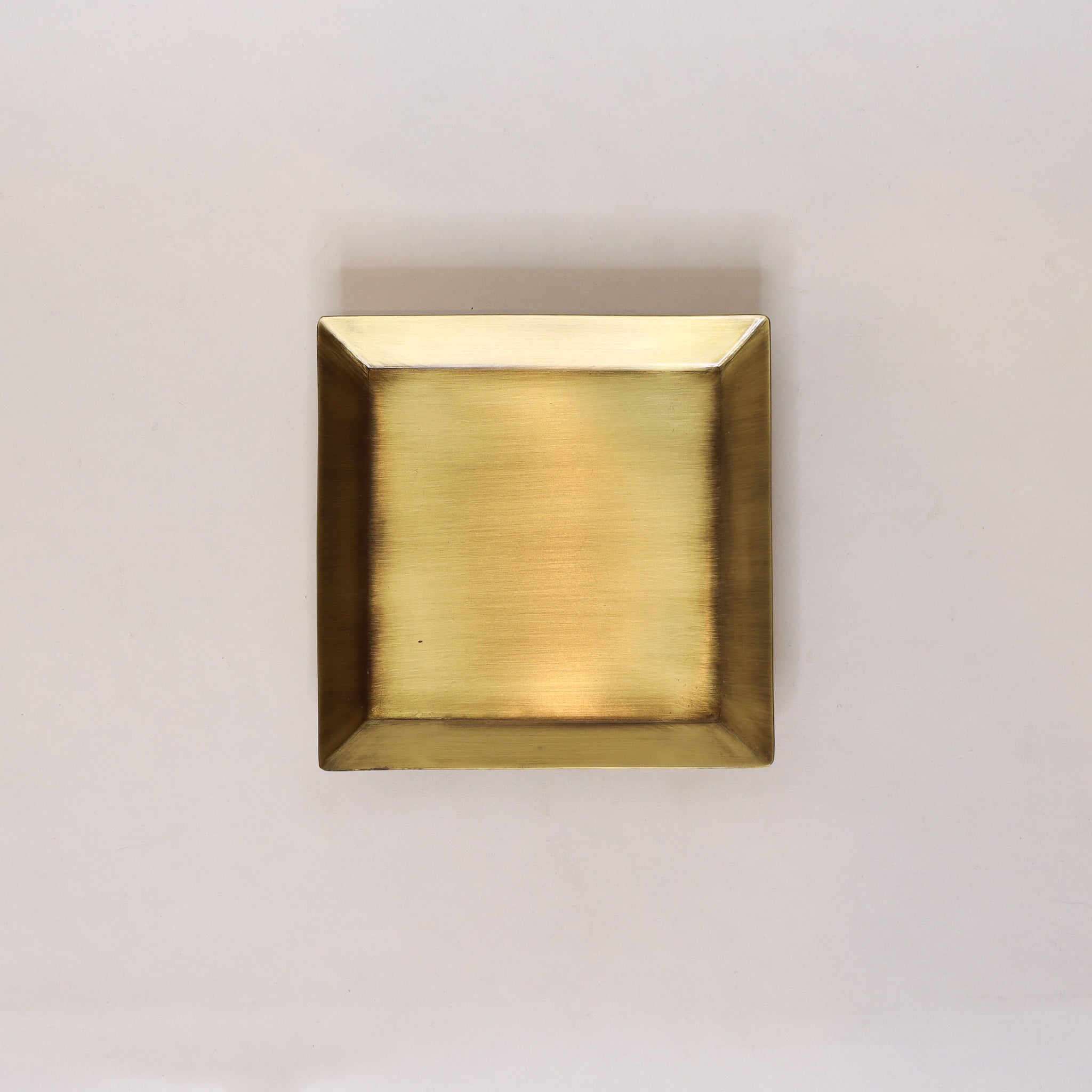 Square brass plate on a light gray background