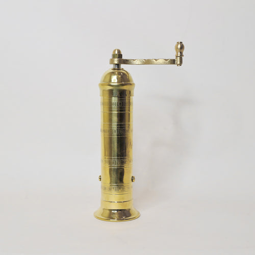 Brass pepper grinder on a white background