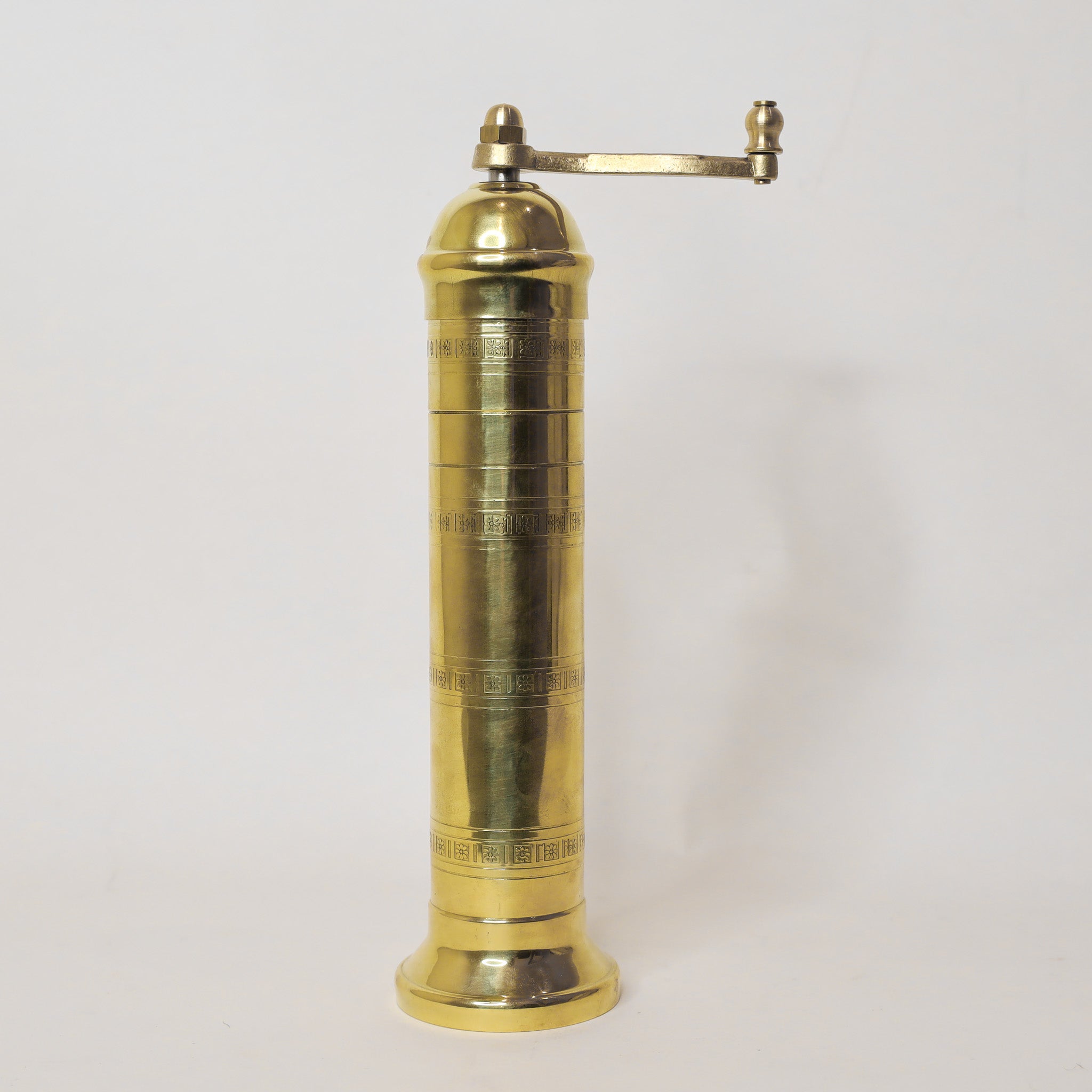 Brass pepper grinder on a white background