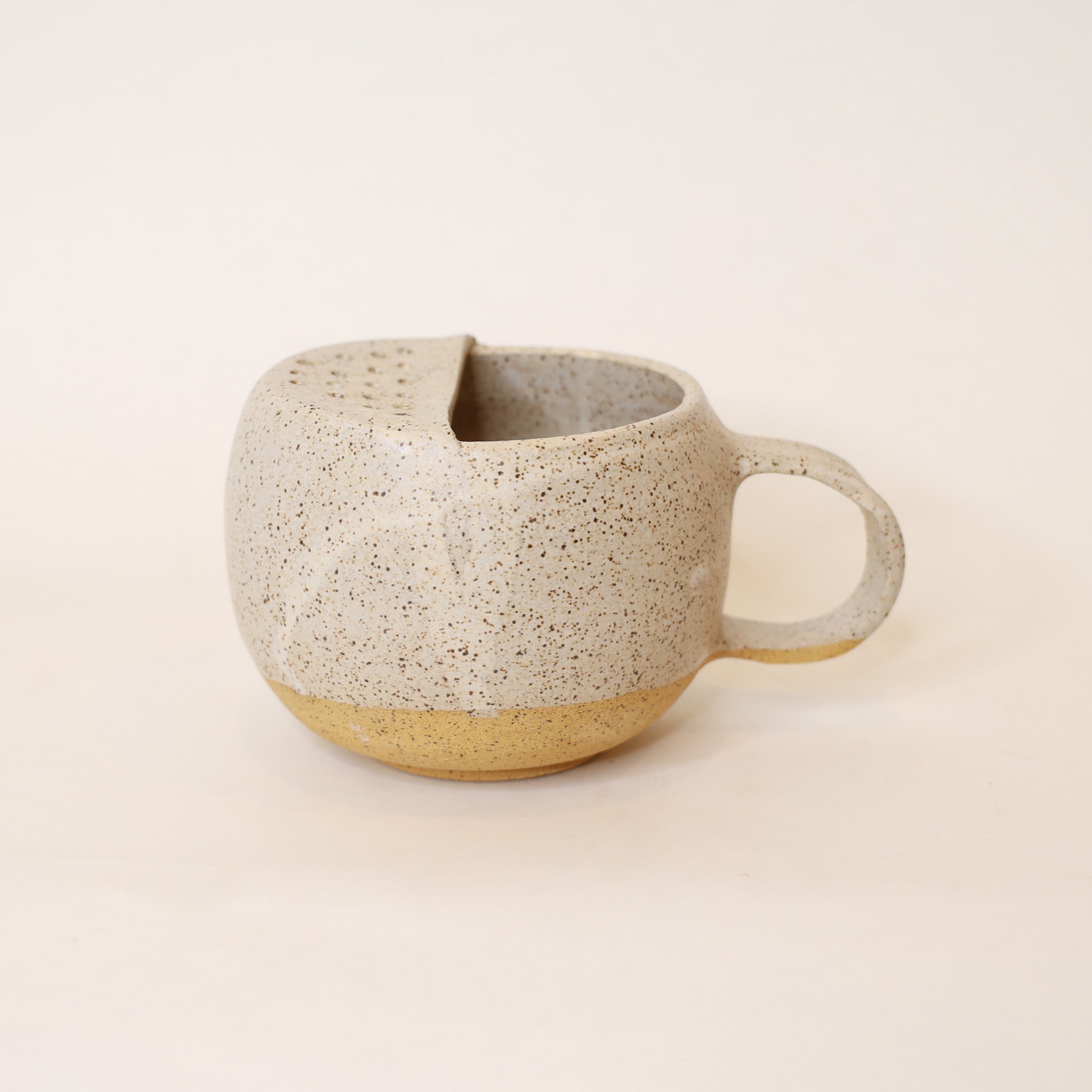 Speckled ceramic mug on a beige background
