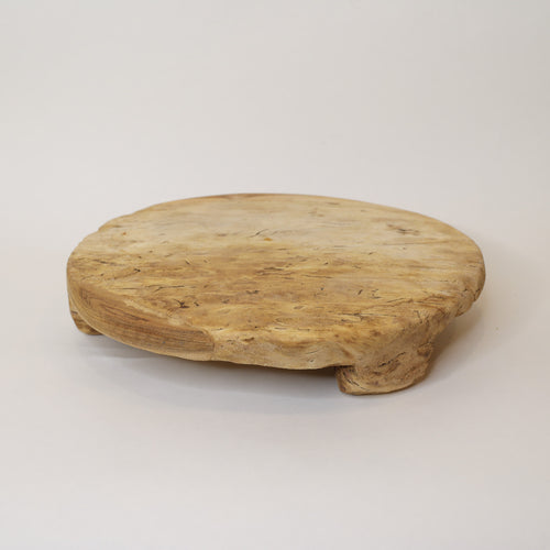 Round wooden tray on a light gray background