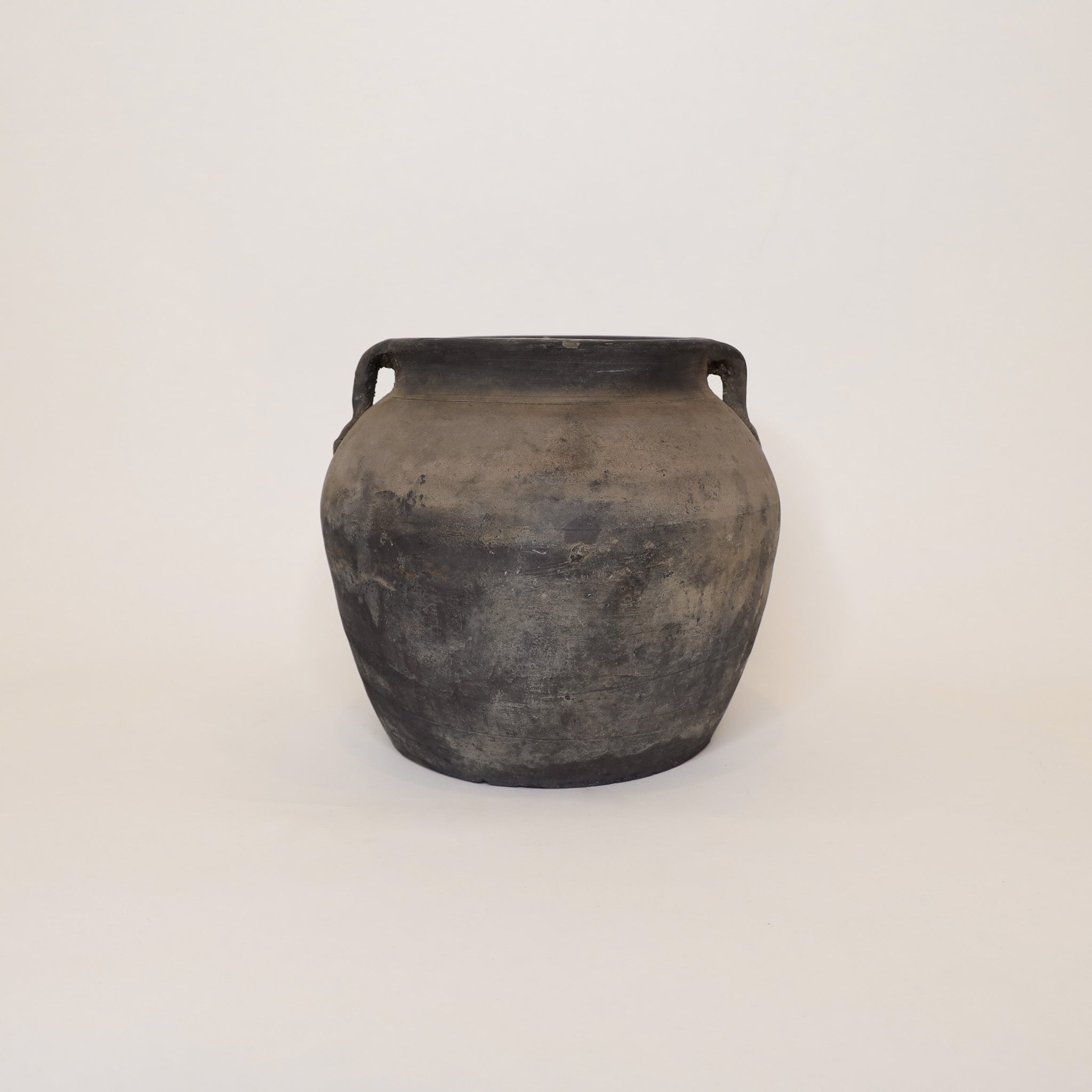 Black ceramic jar with handles on a white background