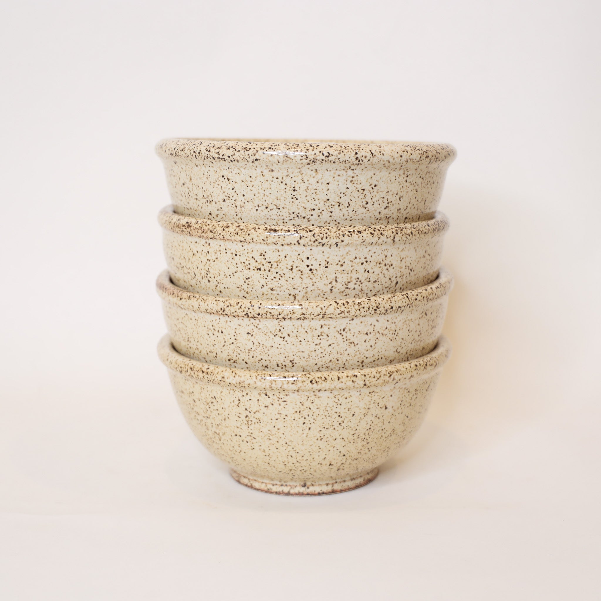 Stack of beige ceramic bowls on a white background