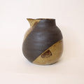 Ceramic pitcher with two-tone brown and beige design on a white background