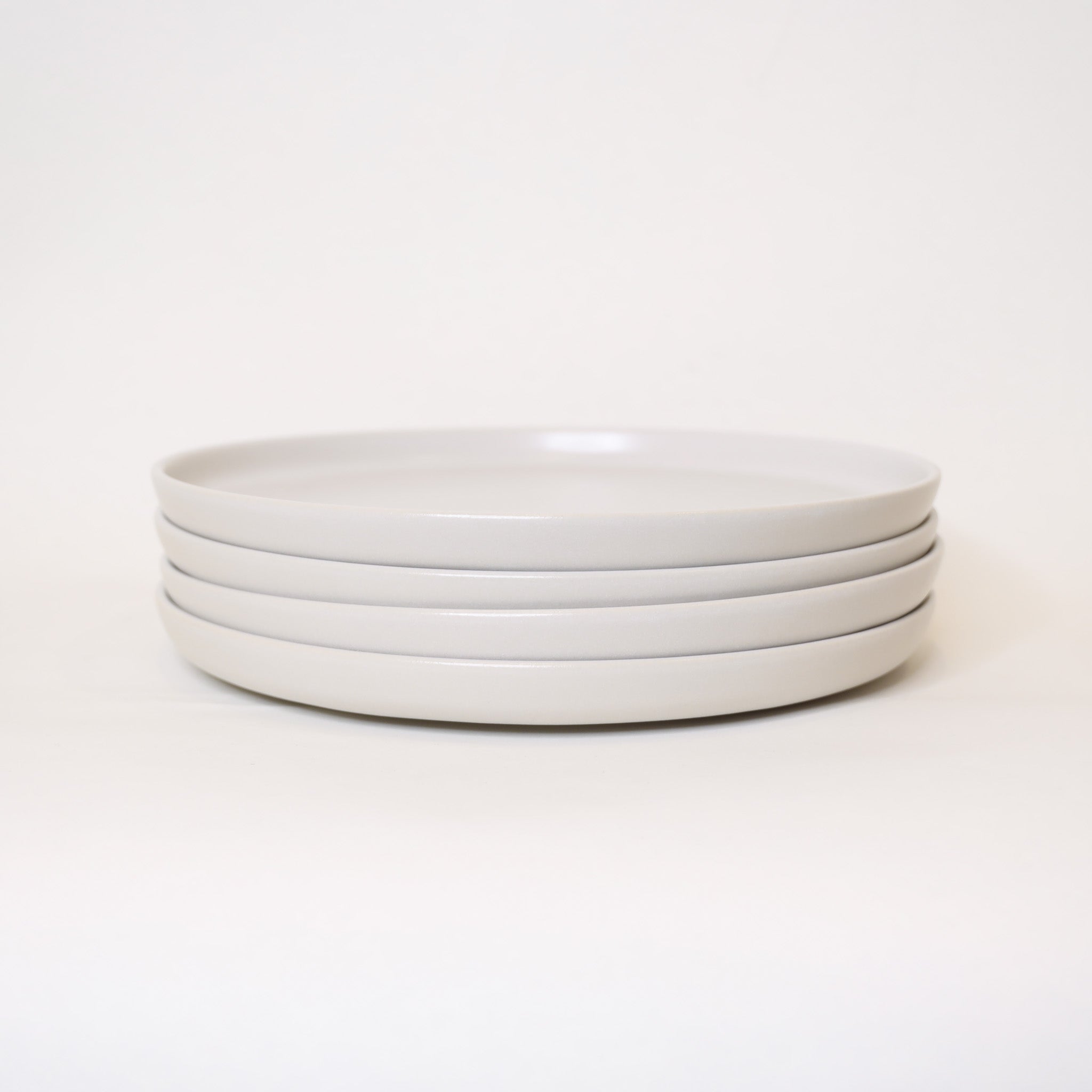 Stack of white ceramic plates on a white background