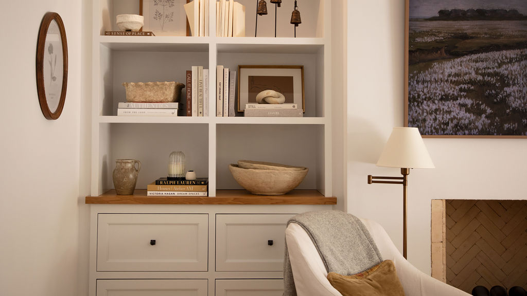 Living room with bookshelf, armchair, and fireplace