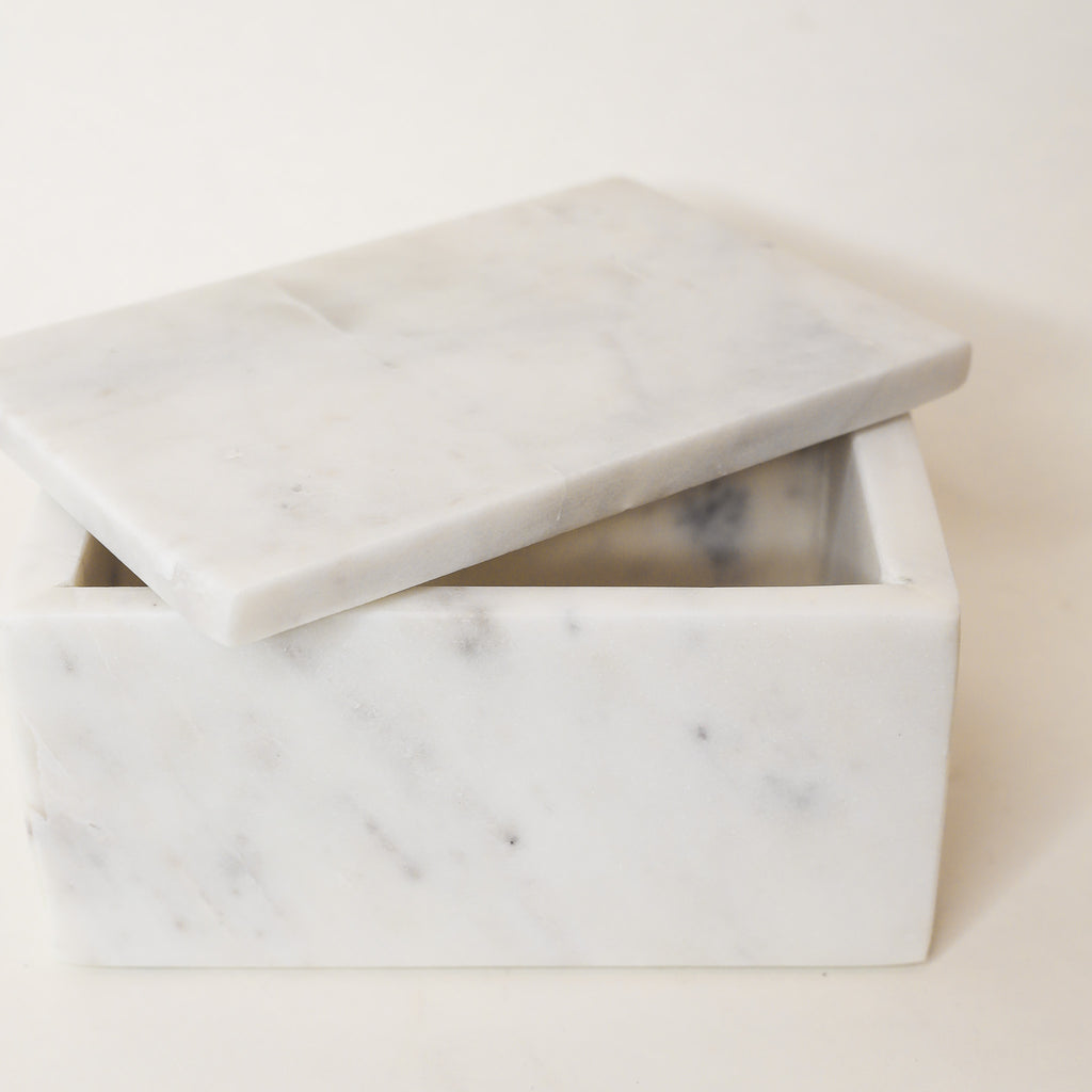 Marble-patterned box with lid on a light beige background