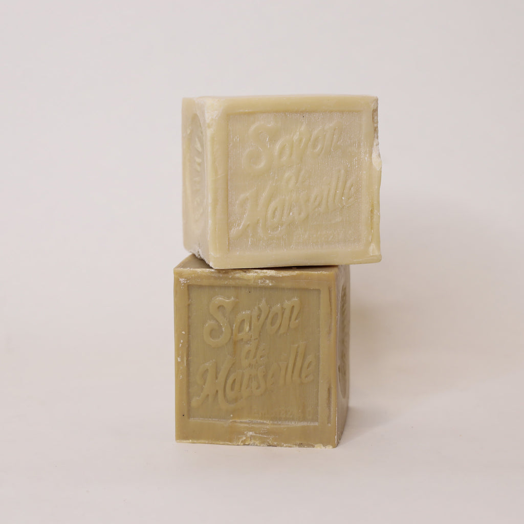 Two bars of soap stacked on a light background with 'Sapon de Marseille' branding.