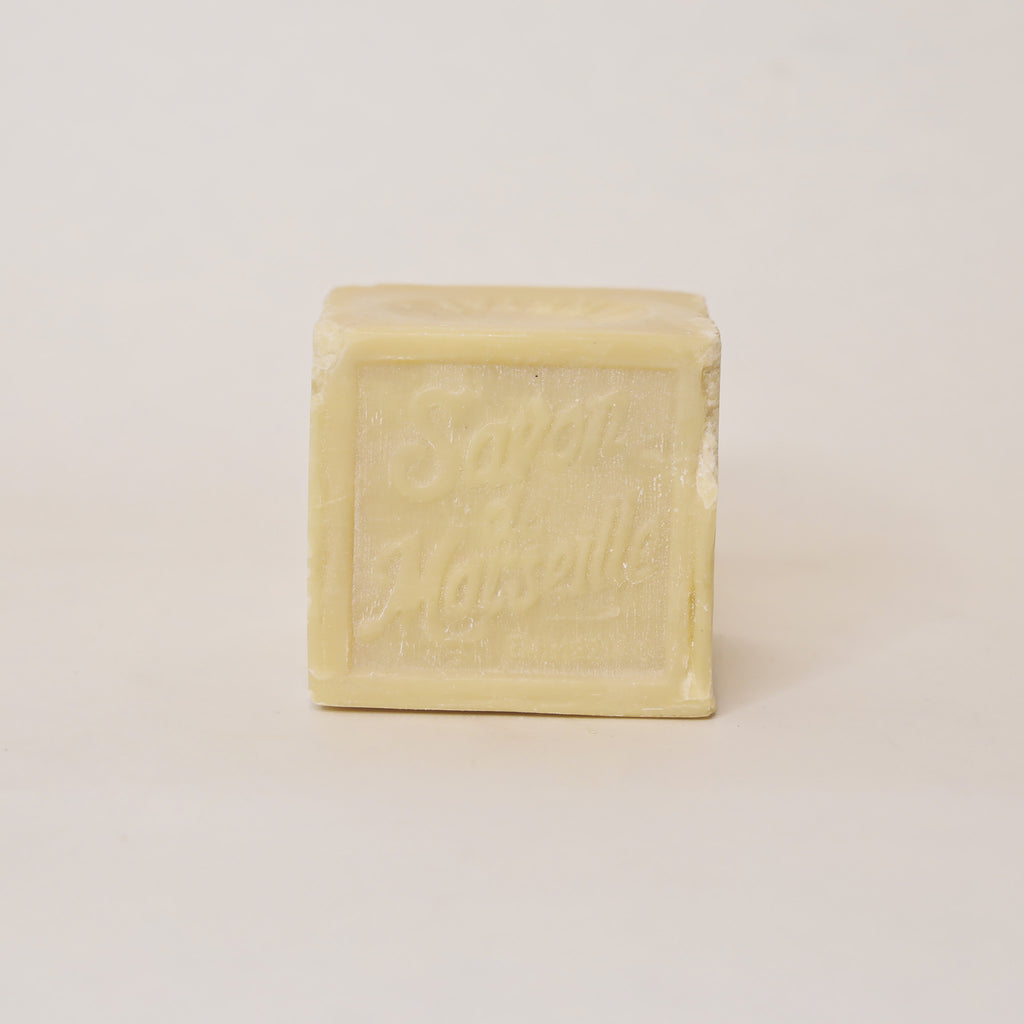 Square bar of soap with 'Savon de Marseille' branding on a light beige background