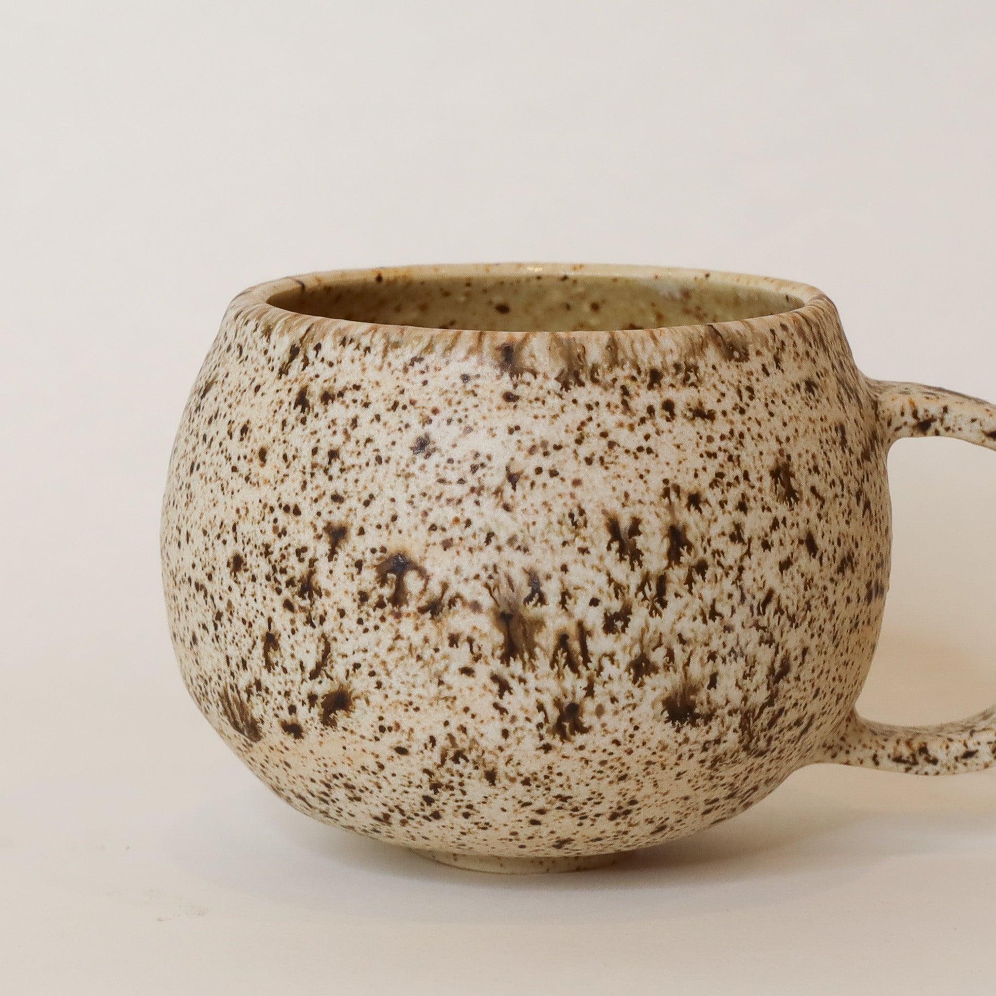 Speckled ceramic mug on a plain background