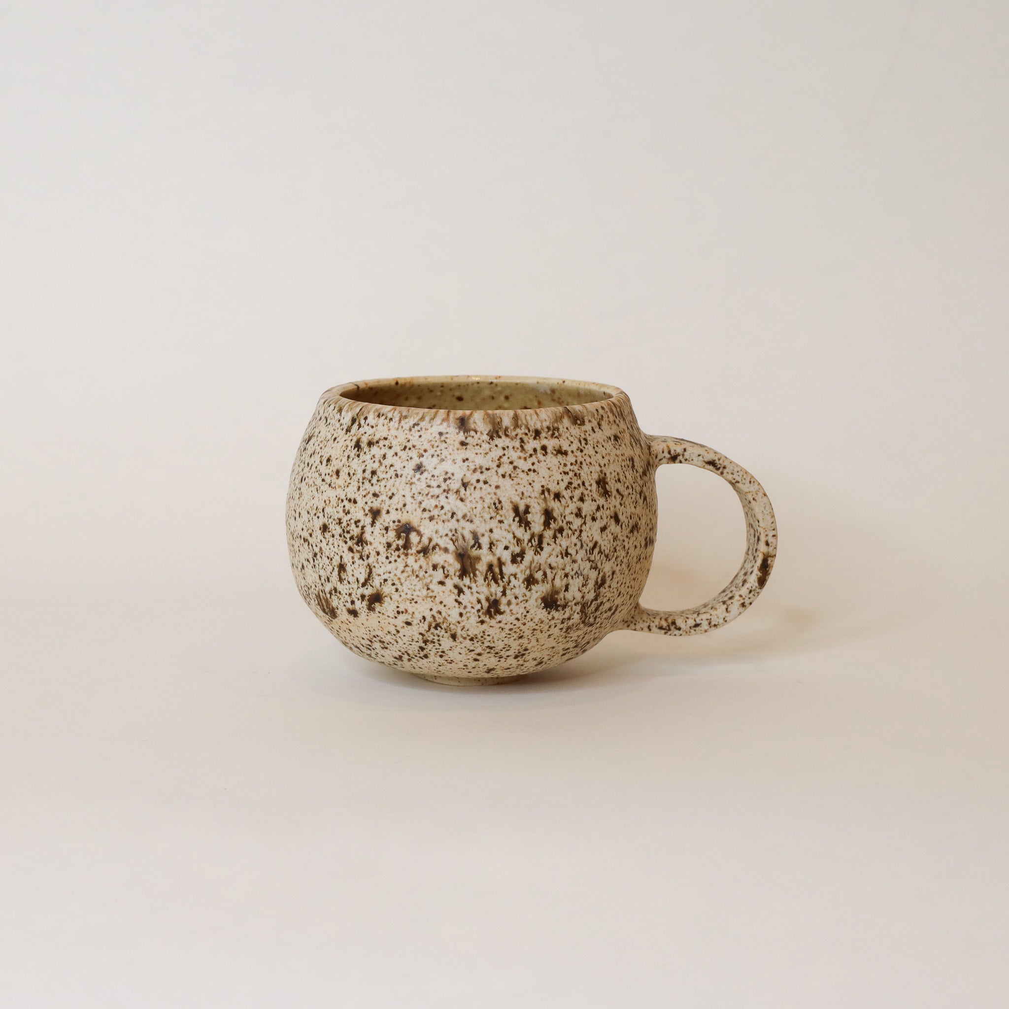 Speckled ceramic mug on a plain background