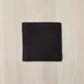 Brown square fabric sample on a light wood surface