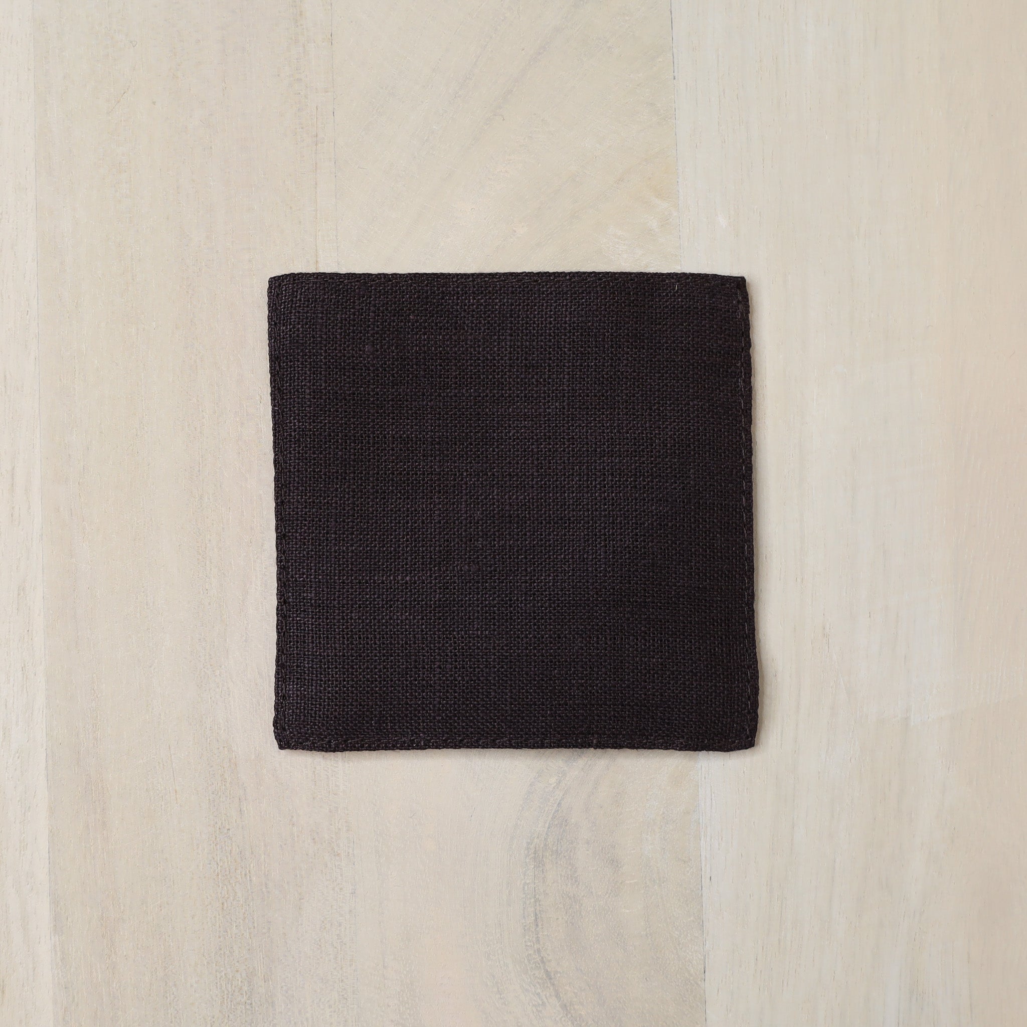 Brown square fabric sample on a light wood surface