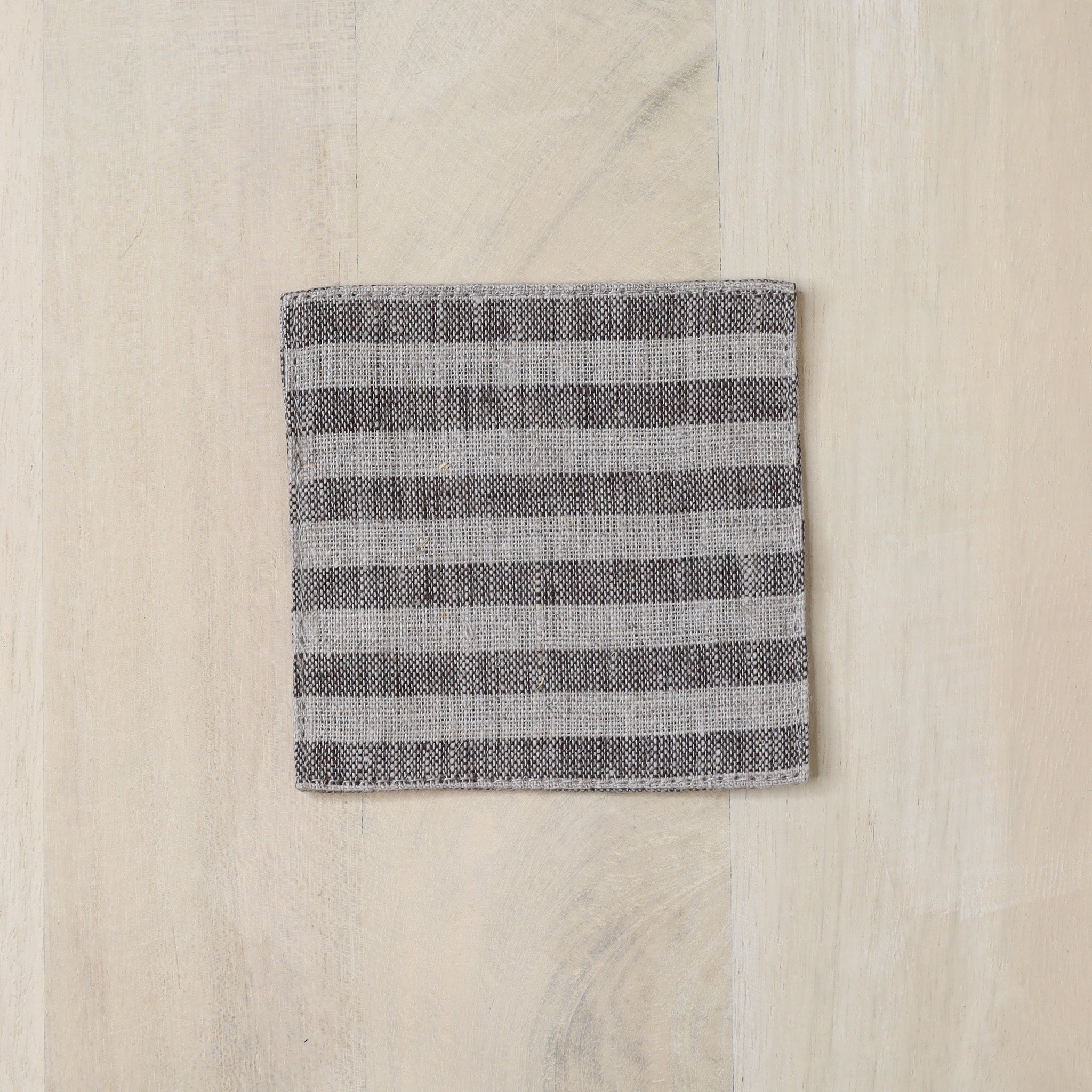Folded fabric with gray stripes on a wooden surface
