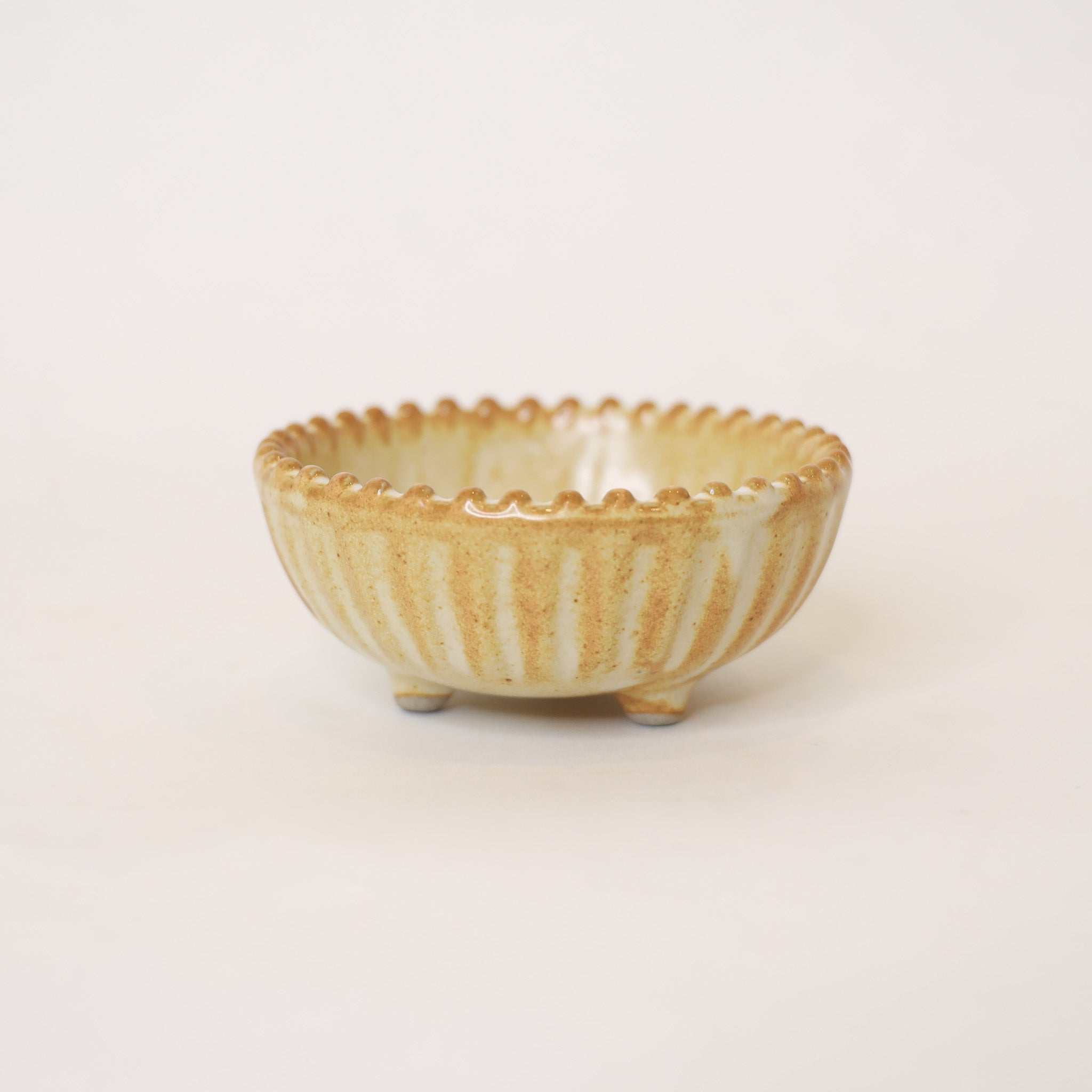 Small ceramic bowl with textured surface on a light beige background
