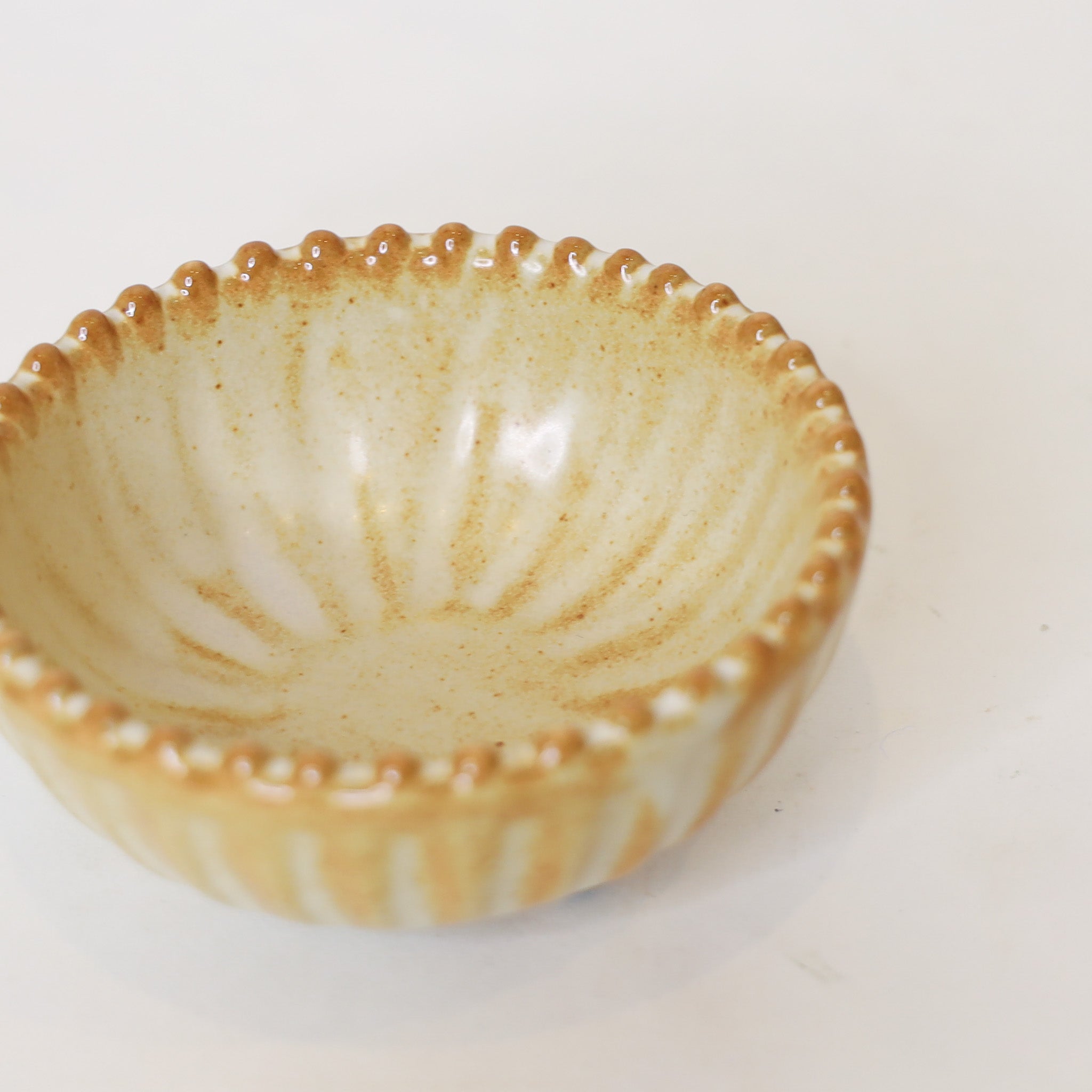Ceramic bowl with textured rim on a white background