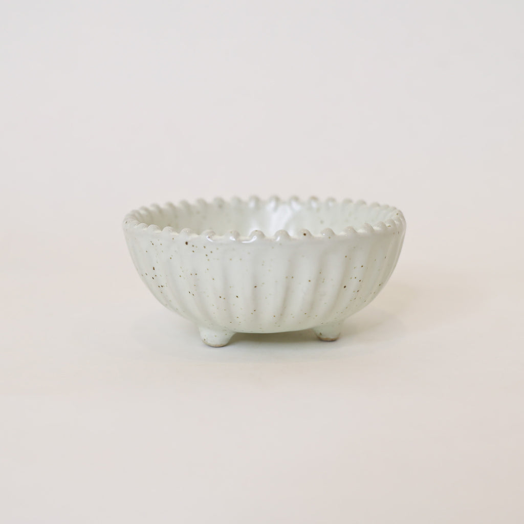 White ceramic bowl with textured surface on a light beige background