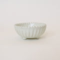 White ceramic bowl with textured surface on a light beige background