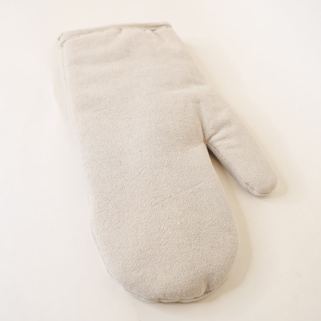 Beige oven mitt on a light beige background