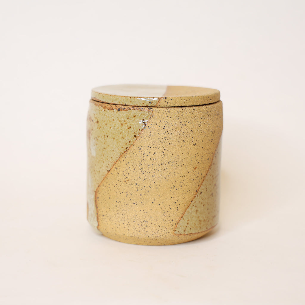 Ceramic jar with a speckled design on a white background