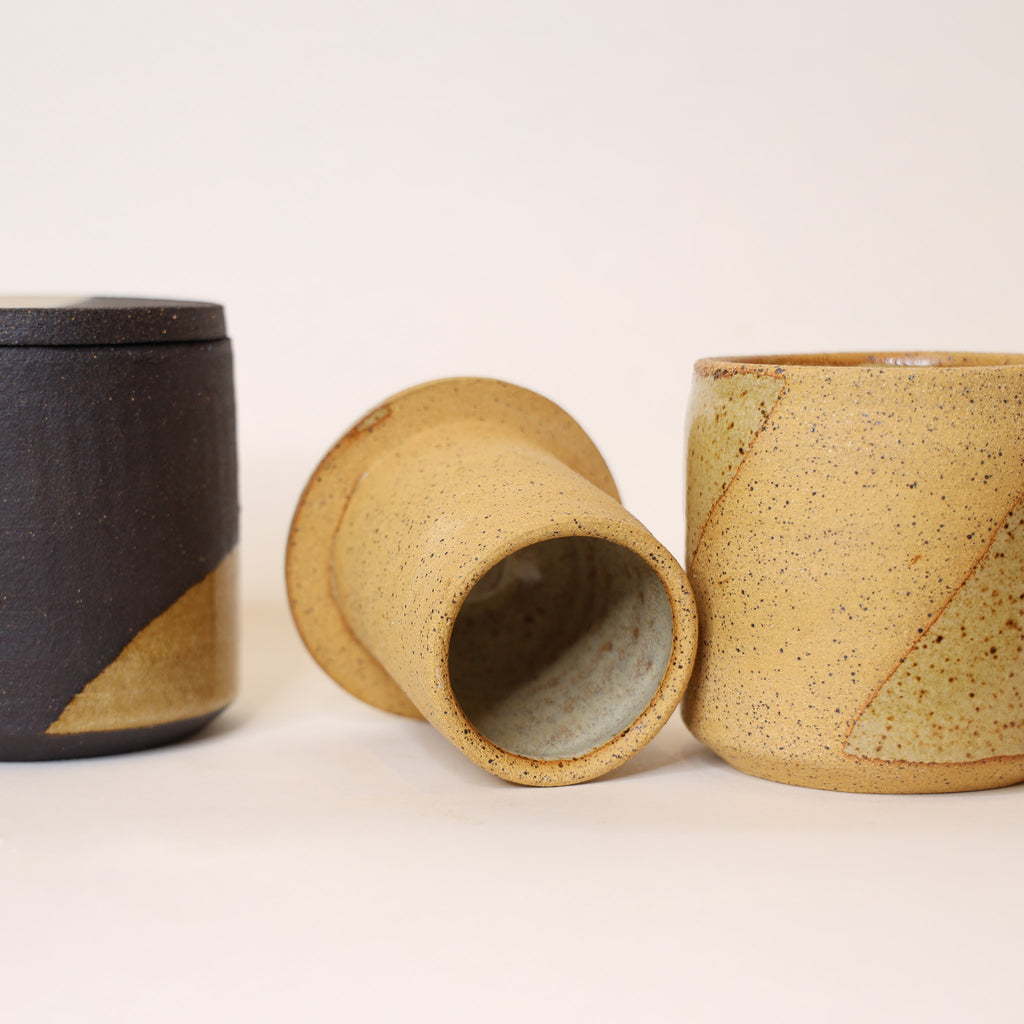 Three ceramic cups with different textures and colors on a light background