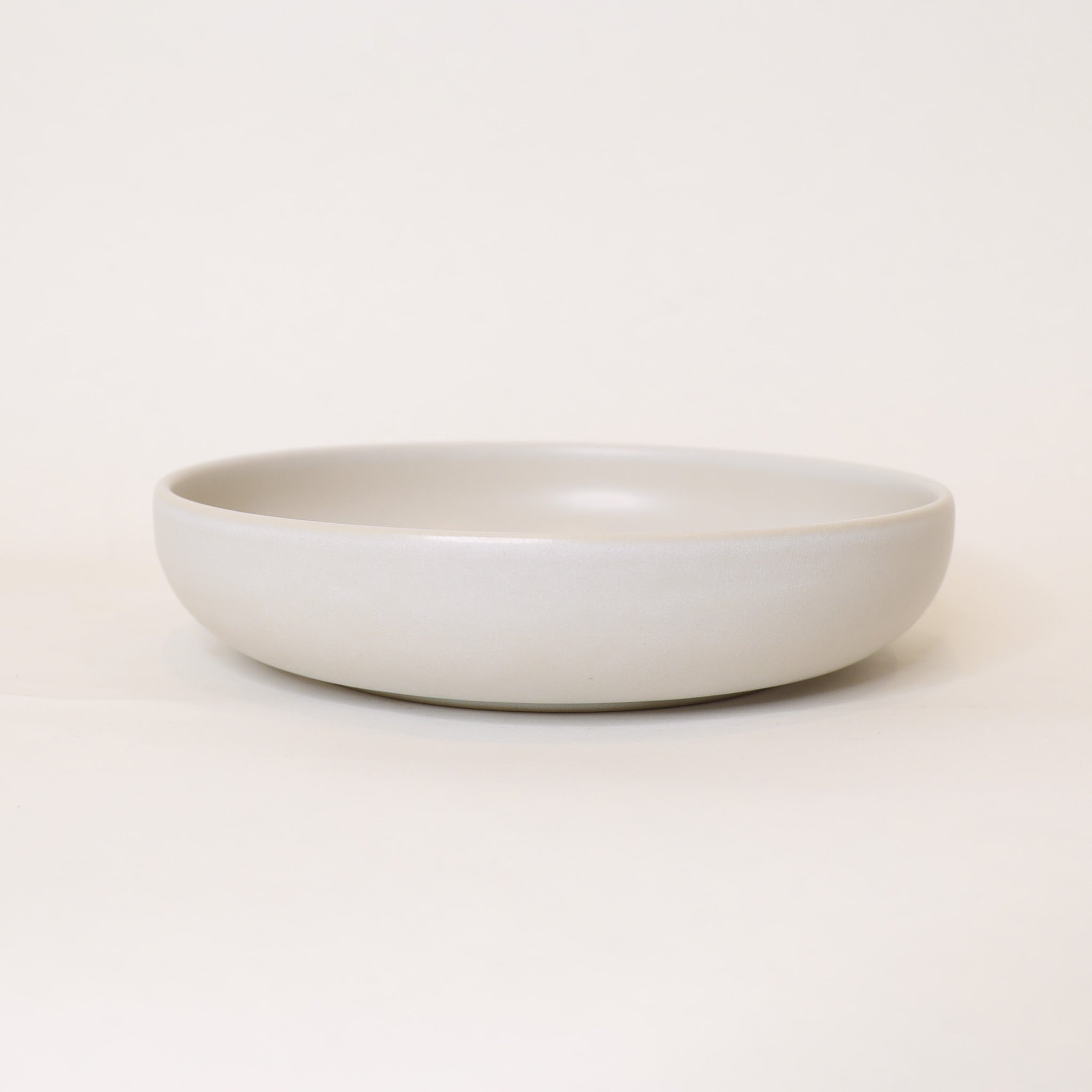 White ceramic bowl on a light beige background