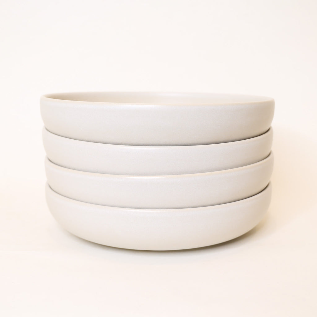 Stack of white ceramic bowls on a white background