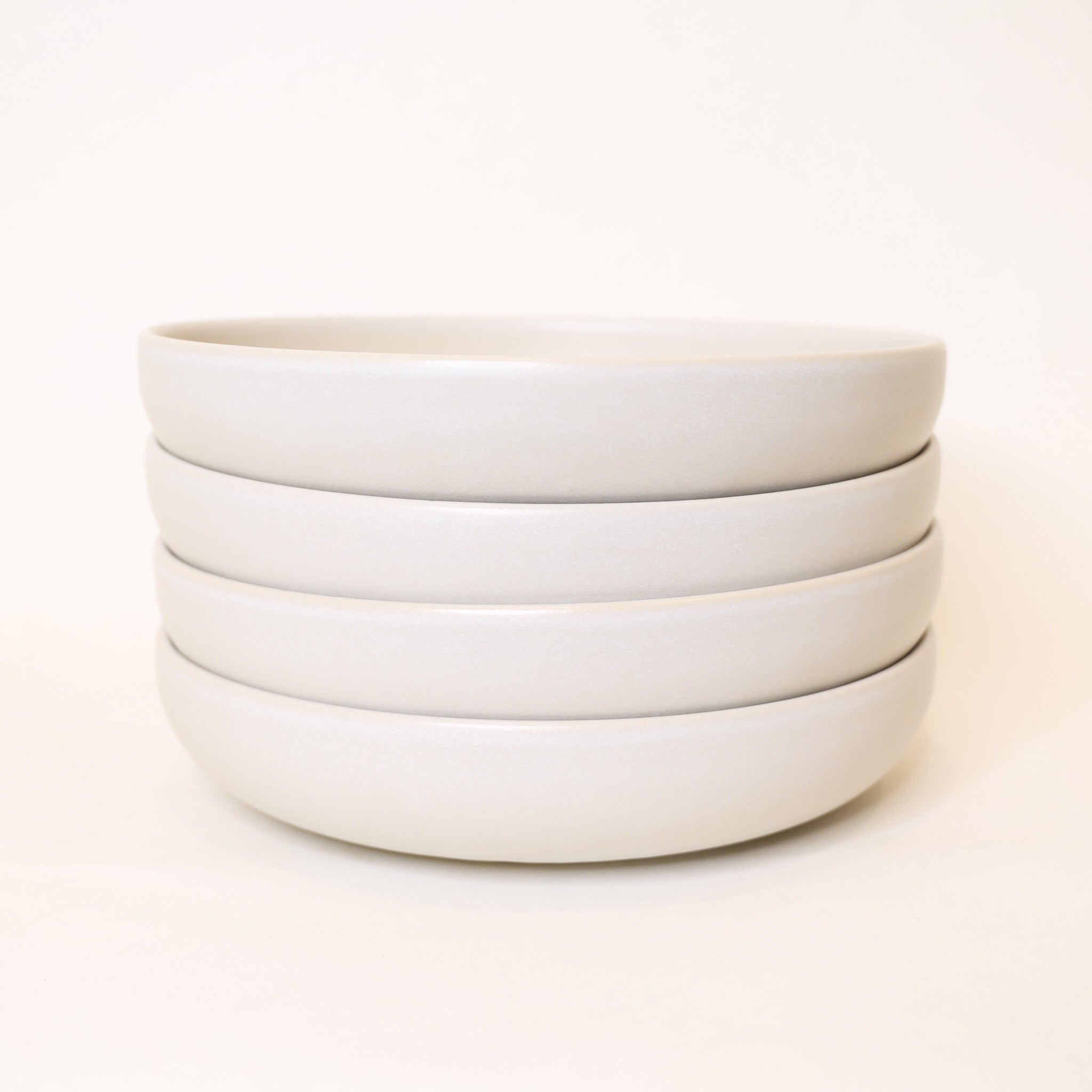 Stack of white ceramic bowls on a white background
