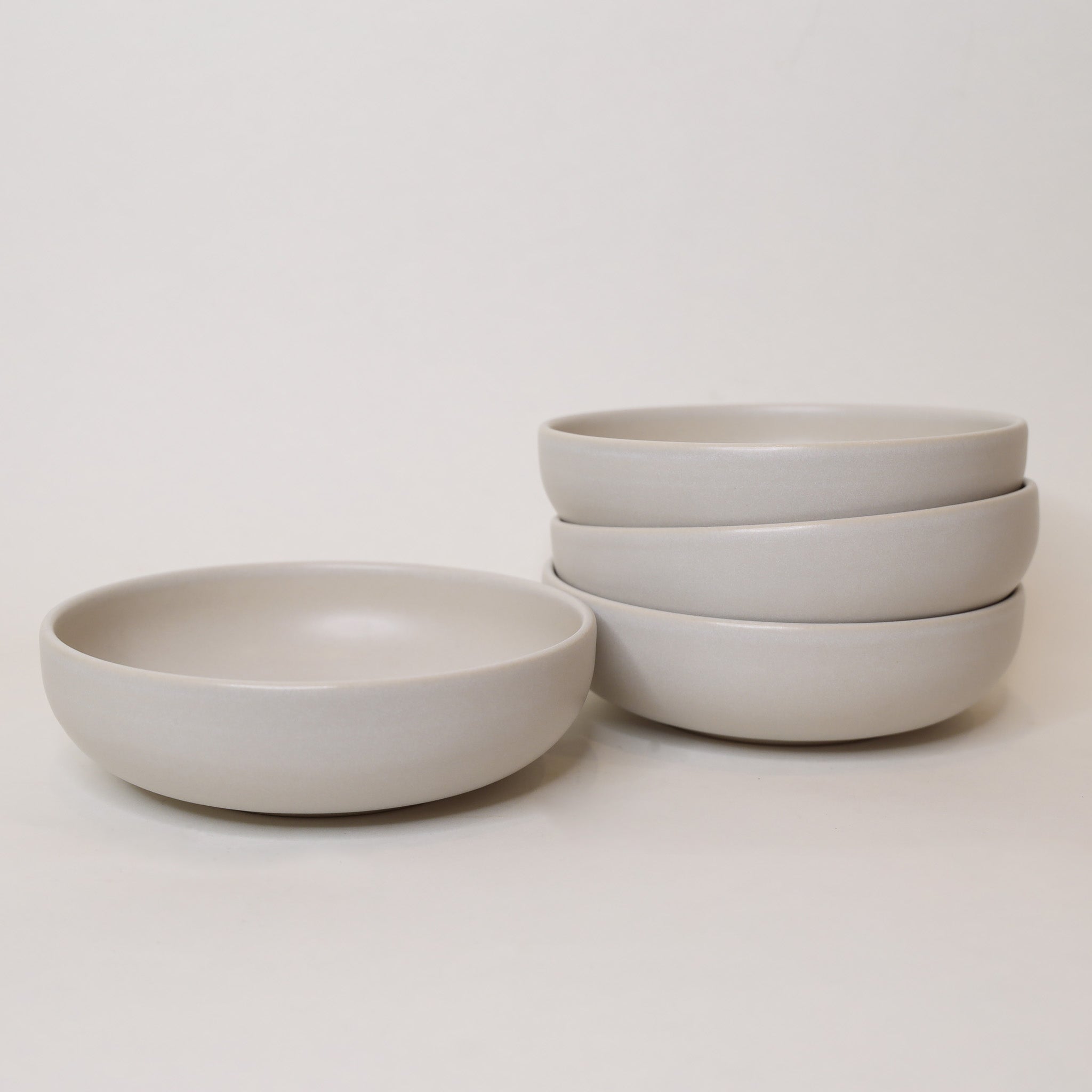 Set of light gray ceramic bowls on a white background