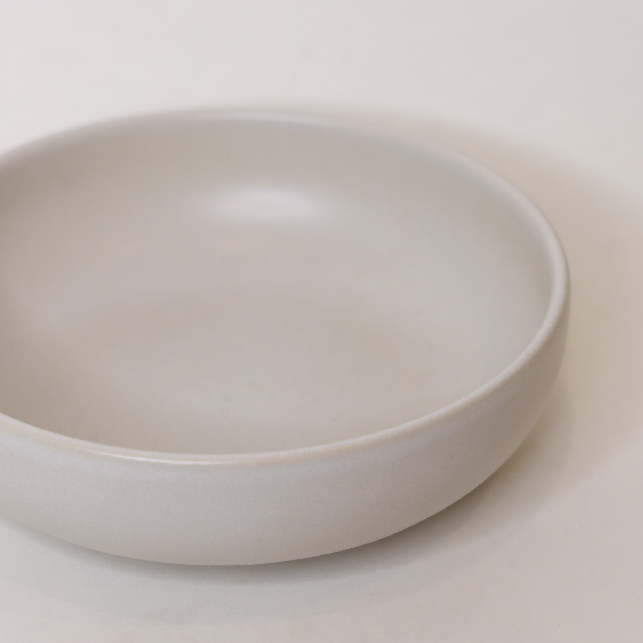 White ceramic bowl on a light beige background
