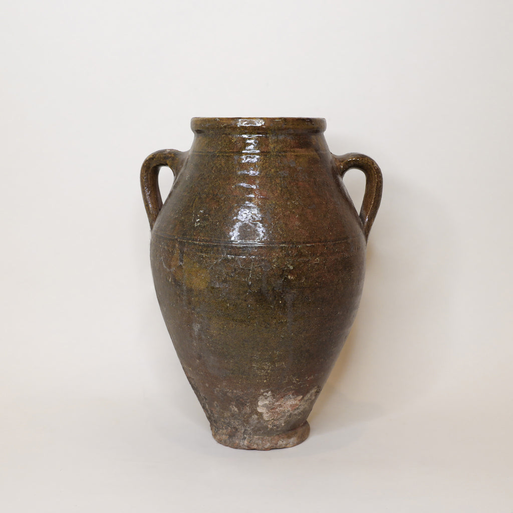 Brown ceramic vase with handles on a white background