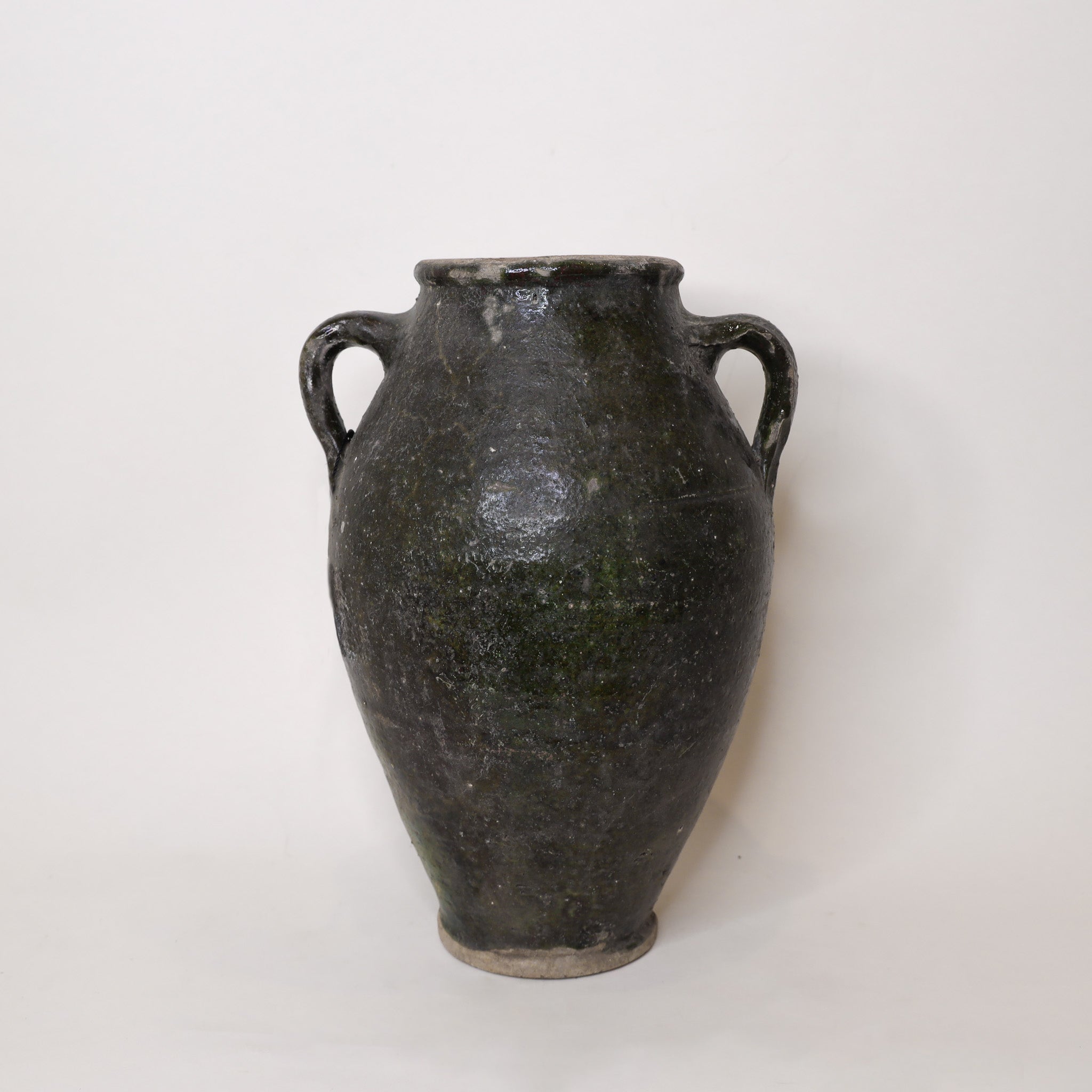 Black ceramic vase with two handles on a white background