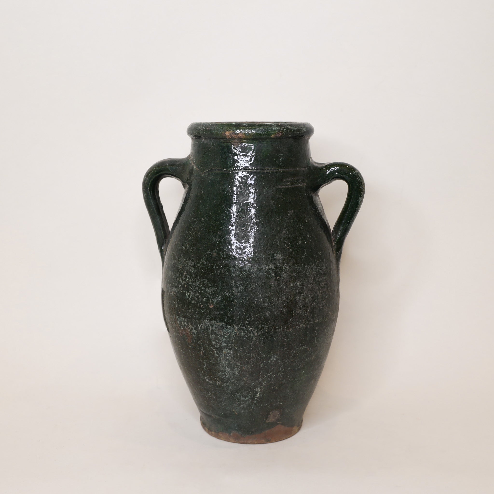 Black ceramic vase with two handles on a white background
