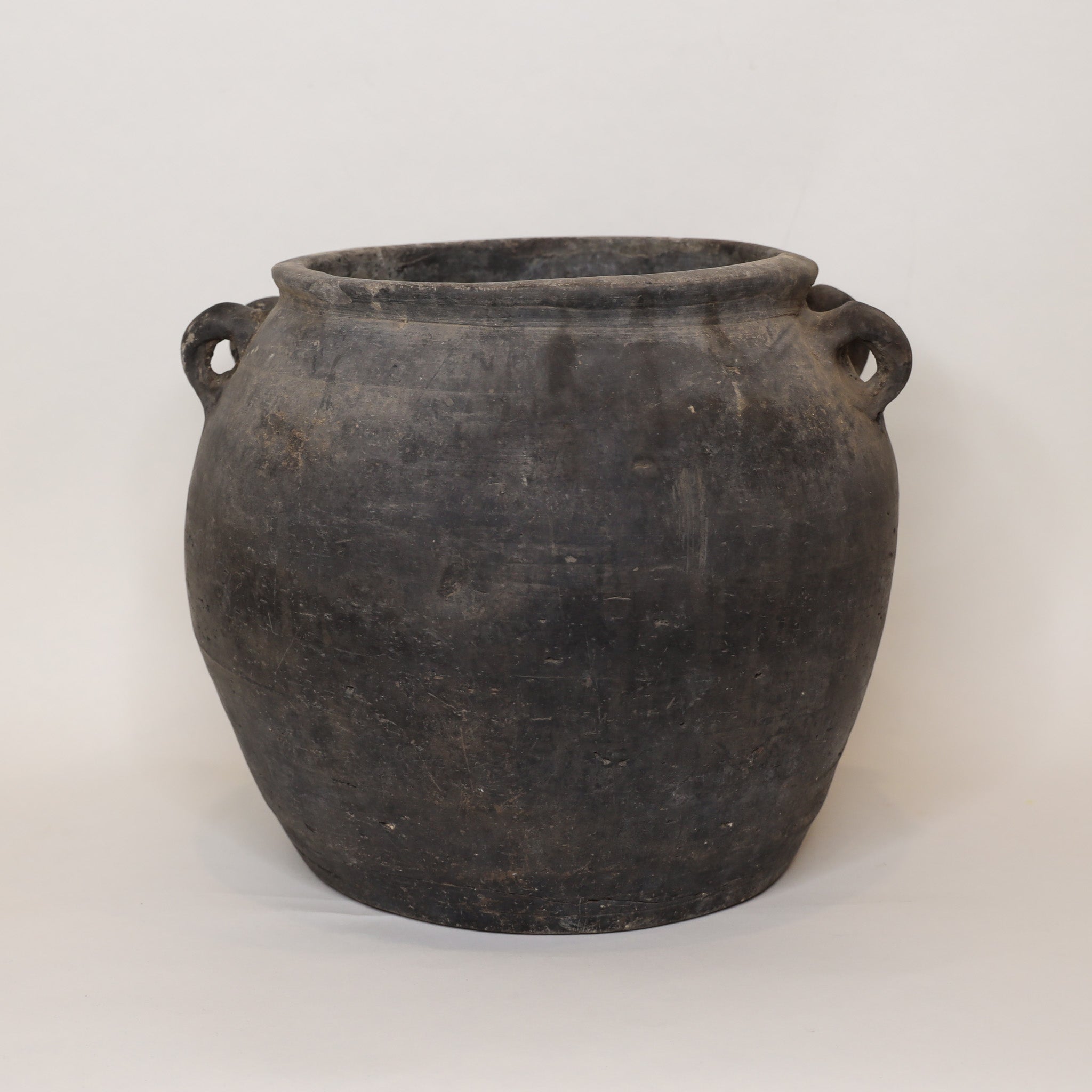 Black ceramic jar with two handles on a white background