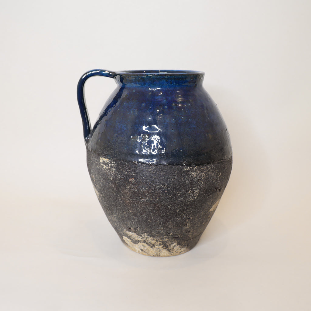 Blue ceramic pitcher on a white background