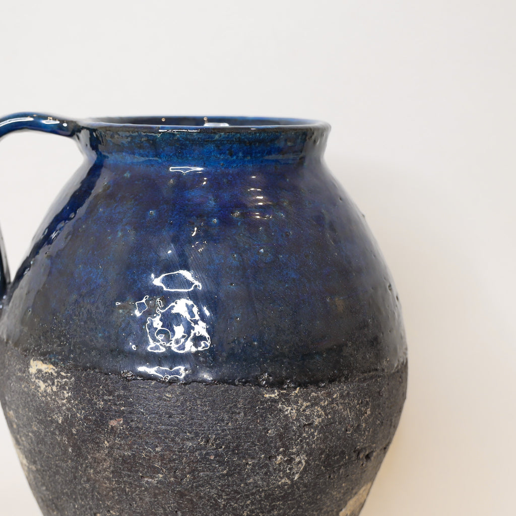 Blue ceramic pitcher on a white background